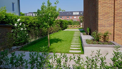 Luxe tuin met gazon, bestrating en plantenbakken