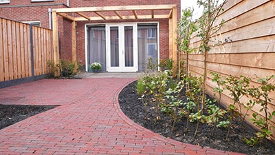 Tuin met rode klinkers en pergola
