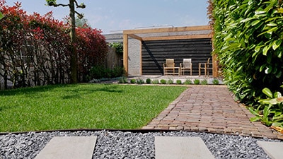 Mooie tuin met gazon, bestrating en houtbouw